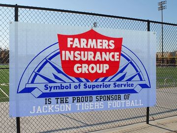 Mesh Banner on chain link fence in front of football field