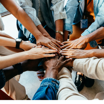 Diverse group of people joining hands in unity and teamwork.