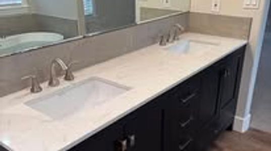 Modern bathroom vanity with double sinks and dark wood cabinetry.