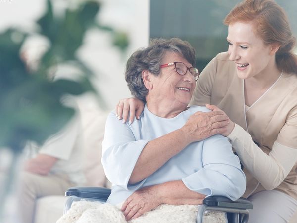 Happy patient holds caregiver for a hand while spending time together