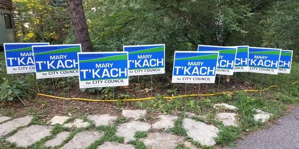 10 yard signs with the text "Mary T'Kach for City Council", waiting for a new home.