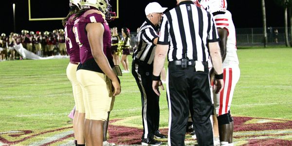 Referee Doug Stevens and Umpire Doug Royer conducting the coin toss before a district contest betwee