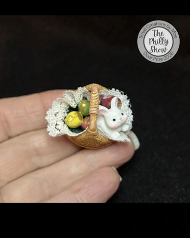Miniature basket with a tiny bunny and fruits.