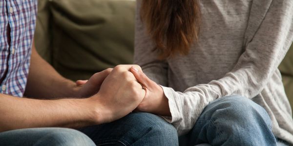 Couple holding hands showing support and care.