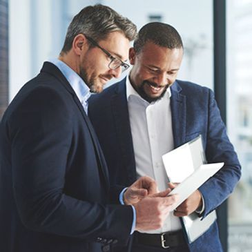 Two businessmen reviewing documents together in an office.