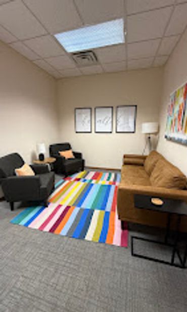 Cozy office lounge with colorful rugs and modern seating.