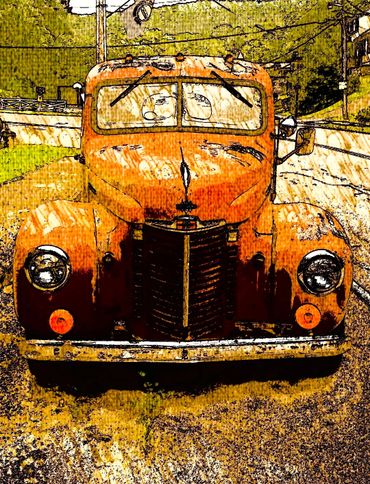 Front view of an old, rusted orange truck with a vintage design.