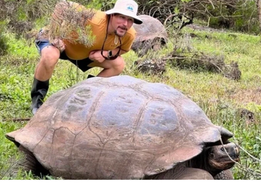 Picture of a man with a giant Galapagos turtle