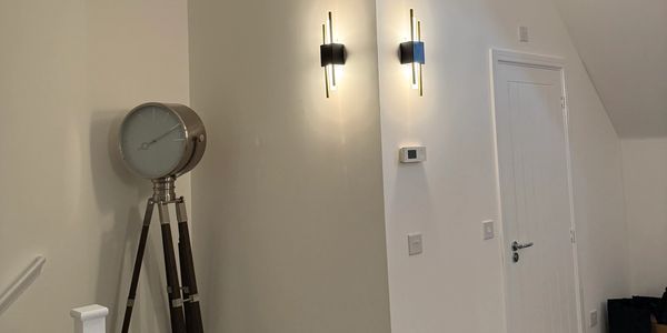 Modern interior with a large tripod clock and wall lights.