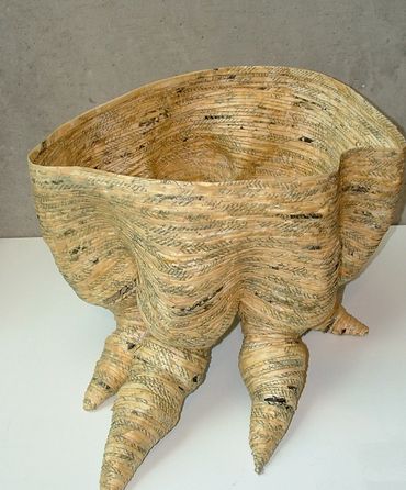 Sculptural basket with curled extensions resembling claws.