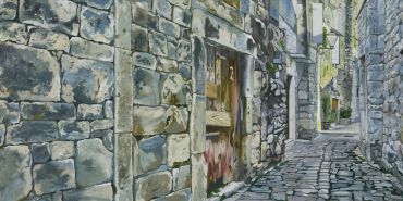 Old stone alleyway with weathered buildings.