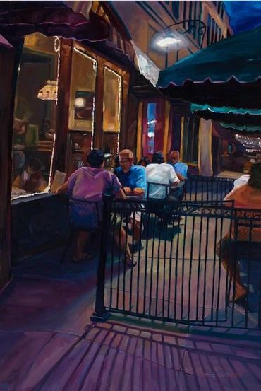 Evening scene of people dining outdoors at a cozy restaurant patio.