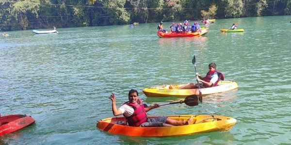 People enjoying kayaking on a calm lake surrounded by trees.