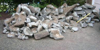 Pile of broken concrete pieces on pavement.