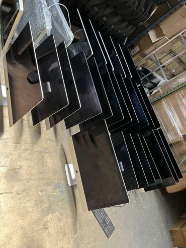 Multiple iMac computers arranged in a warehouse storage area.