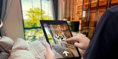 Person using a tablet for a 360-degree virtual tour of a bedroom.