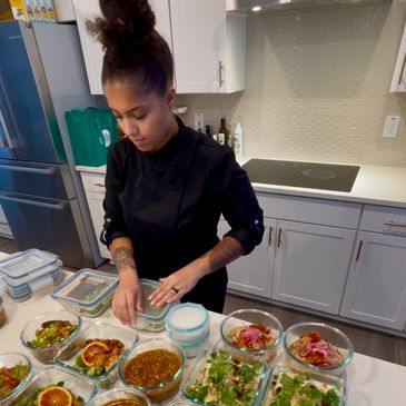 Chef preparing multiple dishes in a modern kitchen.