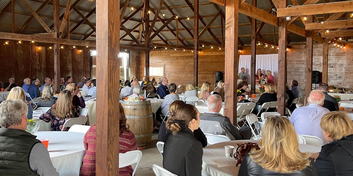 People attending an event in a rustic barn venue.