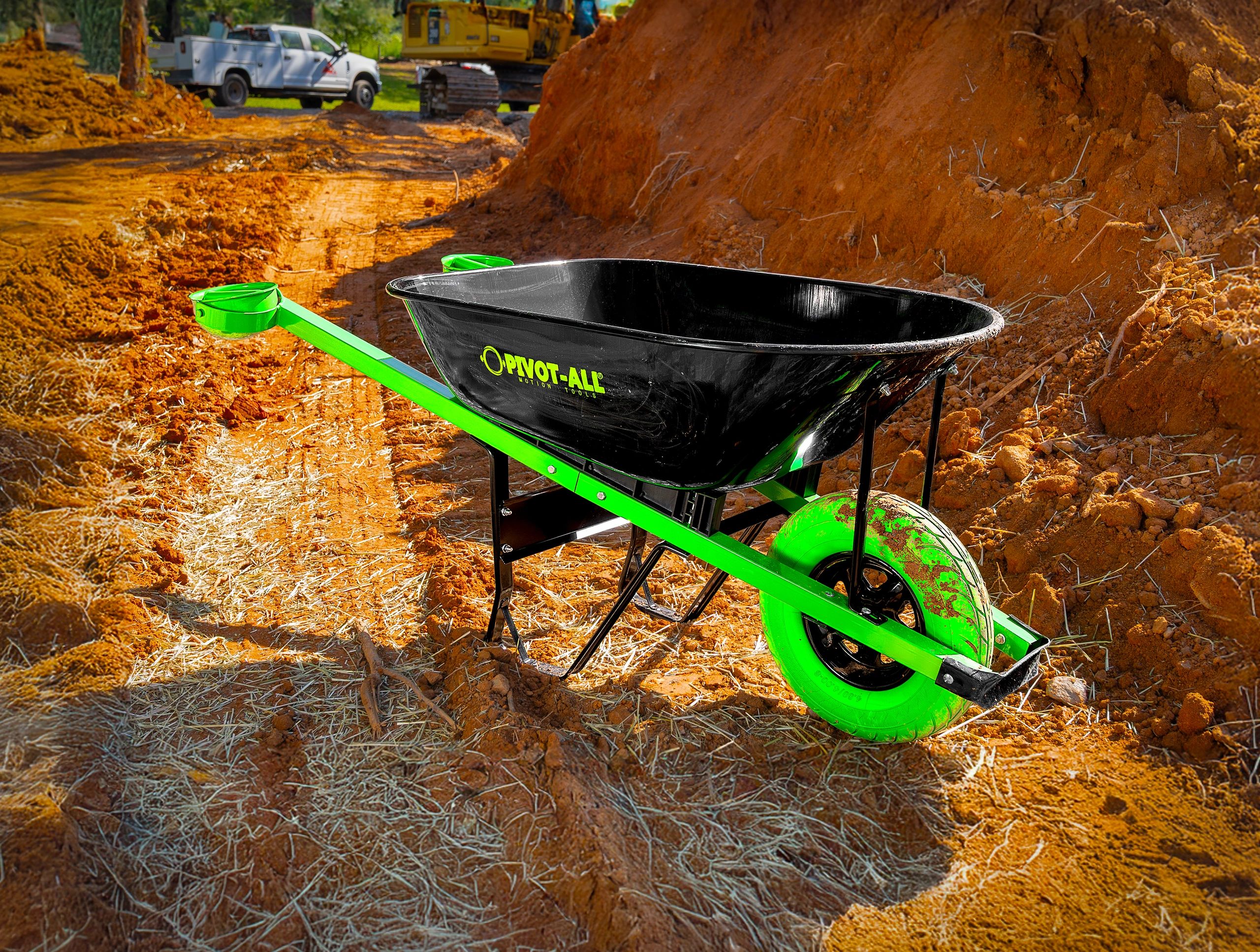 Bright green and black wheelbarrow on a dirt construction site.