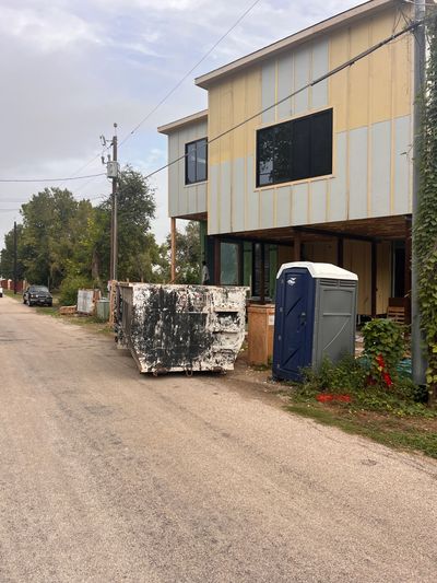 Construction site with dumpster and portable toilet.