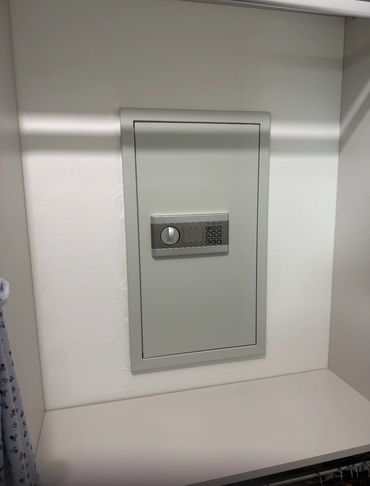 Recessed wall safe fitted neatly into a white interior wall.