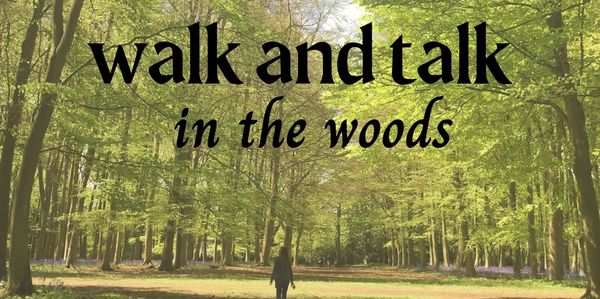 woman walking on path through tall trees