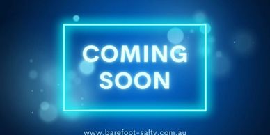 Neon glowing sign with 'COMING SOON' text on a blue background.