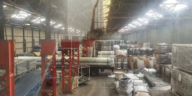 Warehouse filled with stacks of construction materials and equipment.
