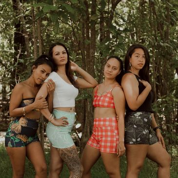 Four women posing outdoors in summer outfits.