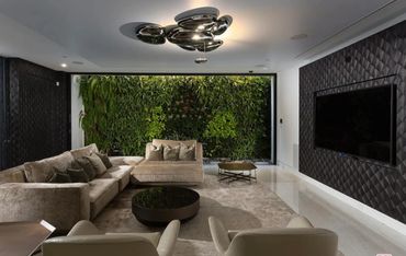 Modern living room with plush seating and a green wall feature.
