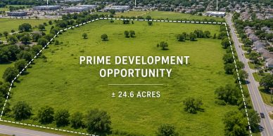 A large 24.6-acre green field marked for prime development opportunity.