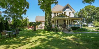 Large house with a spacious green lawn and outdoor seating.