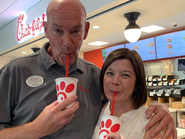 Two people enjoying drinks at Chick-fil-A with red straws.