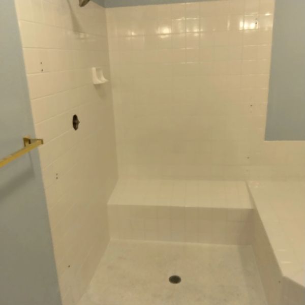 AFTER RE CAULKING, GROUT COLORING DYING AND INSTALLATION OF NEW CAULK TILE AND GROUT CLEANED BY THE