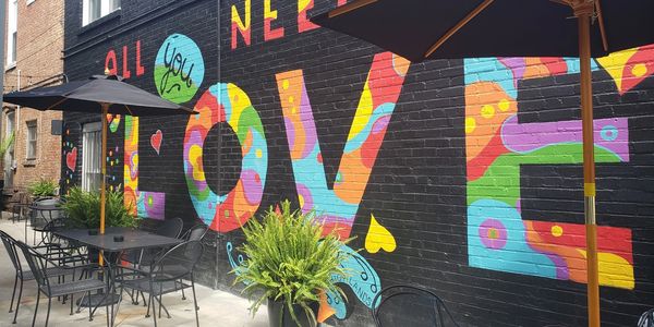 Wall mural titled All You Need Is Love painted by local artist Starvin' Artist. 