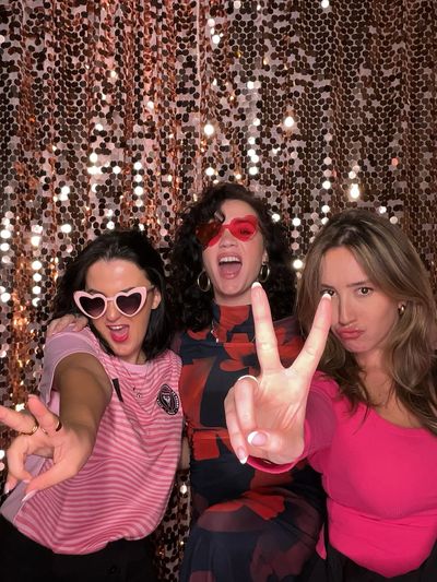 Guests enjoying a fun photo booth experience at a Tampa event with props and playful group interacti