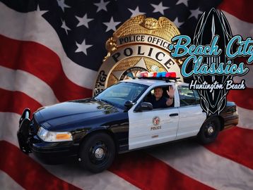 Police car with American flag backdrop and Beach City Classics logo.