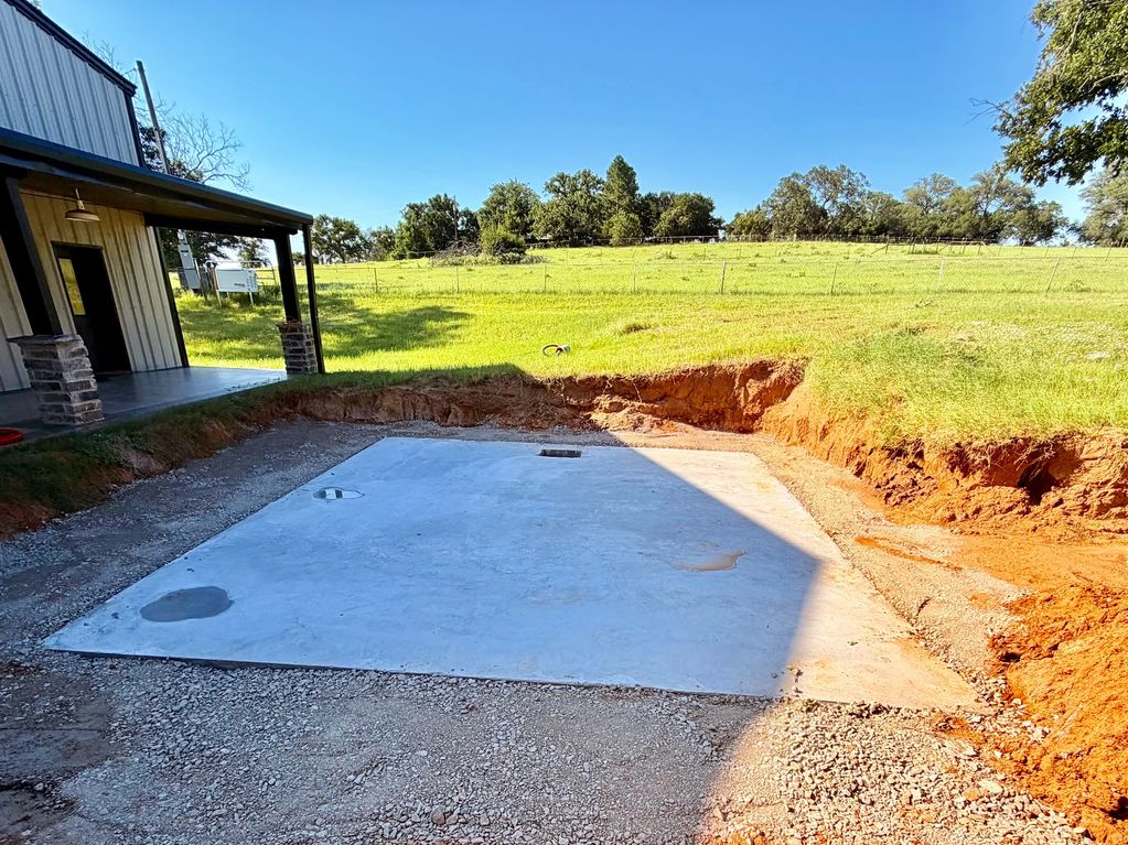 New concrete slab foundation beside a building.