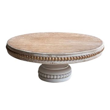 Round wooden stand with beaded design used for displaying.