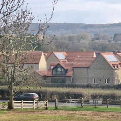 Houses with solar panels on roofs in a rural area.