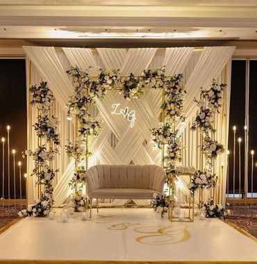 Elegant wedding stage with floral decor and soft lighting.