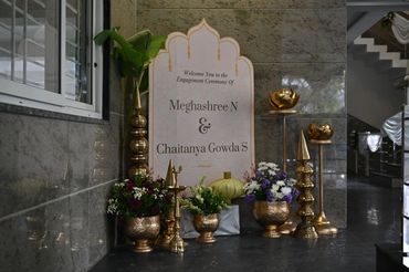 Engagement ceremony decor with flowers and golden ornaments.