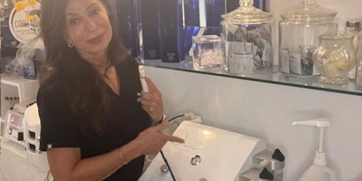 Woman demonstrating a beauty device in a clinic.