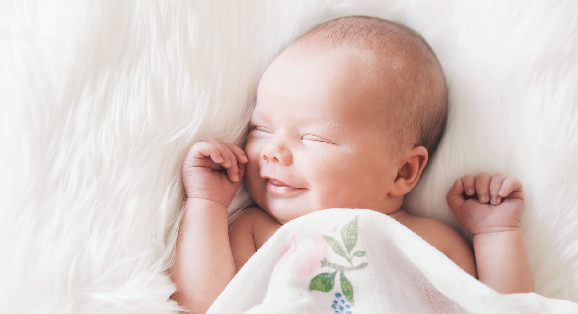Photo of an infant smiling in their sleep