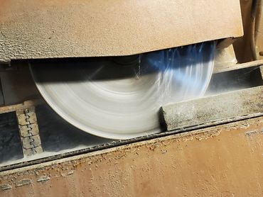 Industrial saw blade cutting stone or similar material with water cooling.
