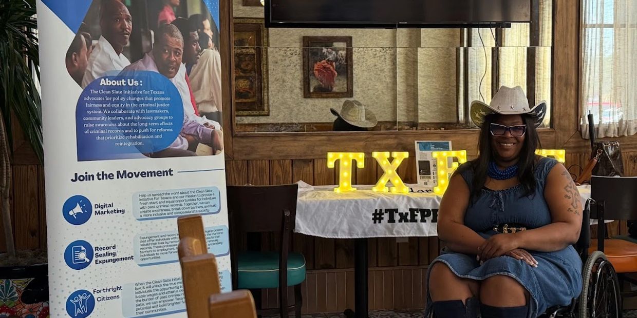 Woman wearing a White cowboy hat with a denim dress blue boots and a retractible baner with TXFPF.