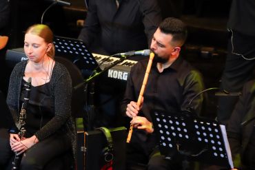 Two musicians playing a clarinet and a nay in a band setting.