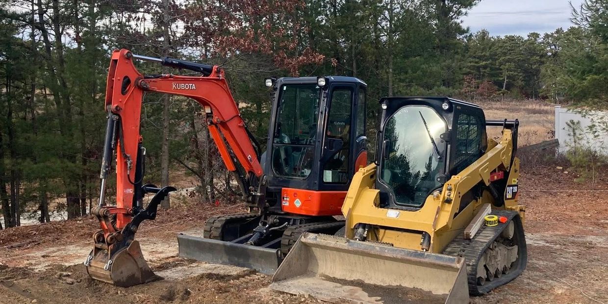 Mini excavator and skid steer on job site in used for excavation, grading, and site preparation.
