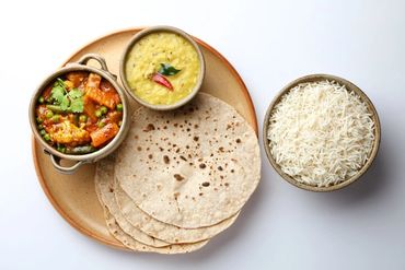 Indian meal with chapati, dal, vegetable curry, and rice.