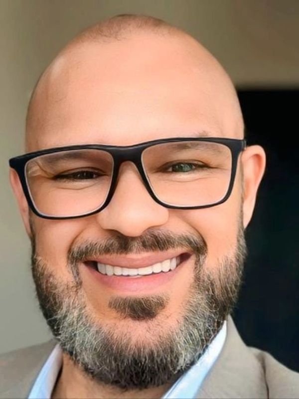 Smiling bald man with glasses and a beard.